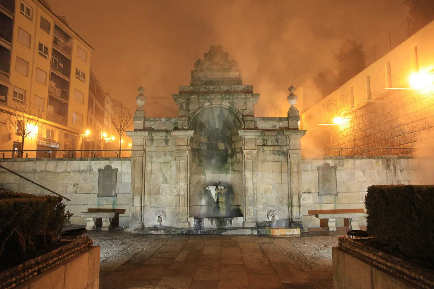 Fuente termal de As Burgas, en Ourense, de noche, con el vapor del agua caliente envolviendo la fuente de piedra